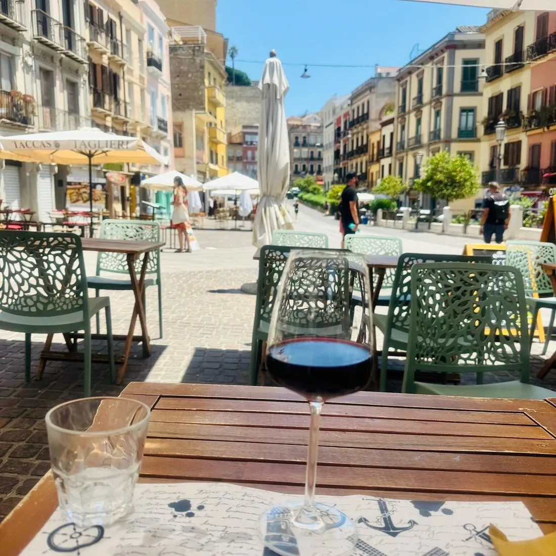 I tavolini del Deja Vu Bistro nel tratto pedonale del Corso Vittorio Emanuele II a Cagliari, con le facciate colorate dei palazzi di Stampace