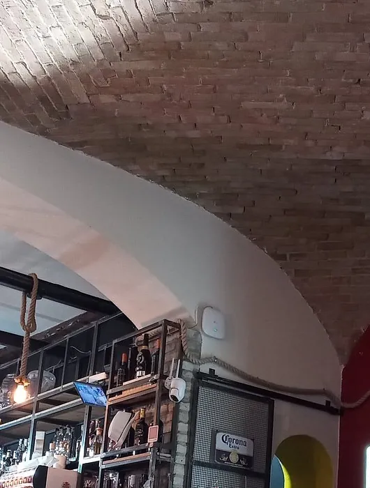 La volta di mattoni a vista della sala interna con gli scaffali delle bottiglie